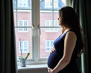 pregnant woman at window in Massachusetts