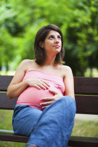 pregnant woman sitting on a park bench