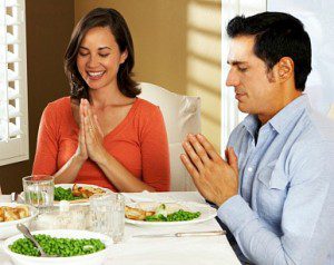 couple praying together at mealtime