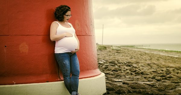 pregnant woman standing on a beach
