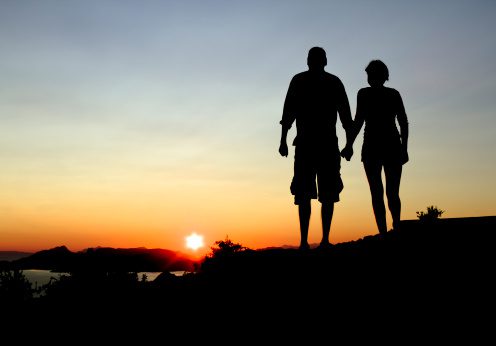Silhouetted photo of a couple watching the sunset
