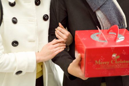 Cropped photo of a couple, husband carrying Christmas present