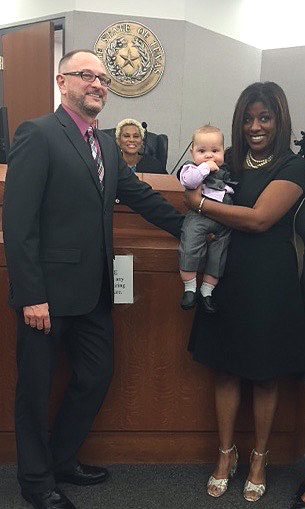 Judge finalizes adoption and new family poses with her after a successful adoption with help from an attorney