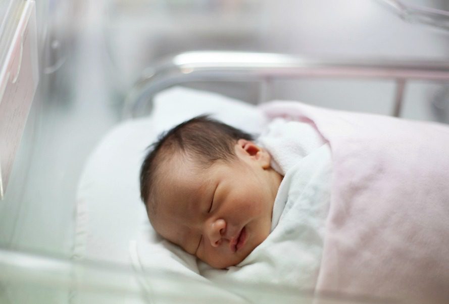 Newborn baby in a hospital bassinet