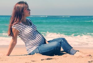 A pregnant woman near Orlando sitting on the beach