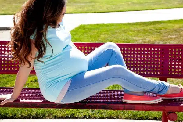 Pregnant woman relaxing on a park bench