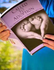 Close up on adoption book read by a woman outside