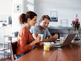 Couple sitting at their computer together getting their adoption home study materials ready