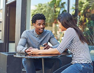 Young couple meet at outdoor café excited to get started with the adoption process