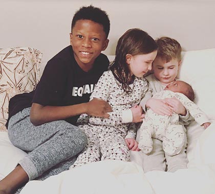four adopted children from different birth parents pose together as one family now