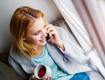 Woman talking on the phone to a Lifetime Adoption staff member, available after hours and weekends