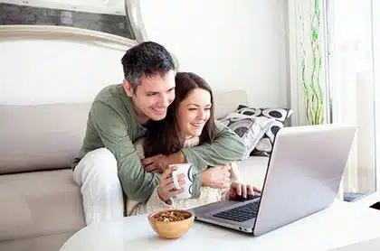 Couple looking at website on computer learning more about modern open adoption through Lifetime Adoption