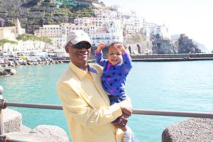 US citizens adoptive family living overseas smile while standing in front of an Italian scene