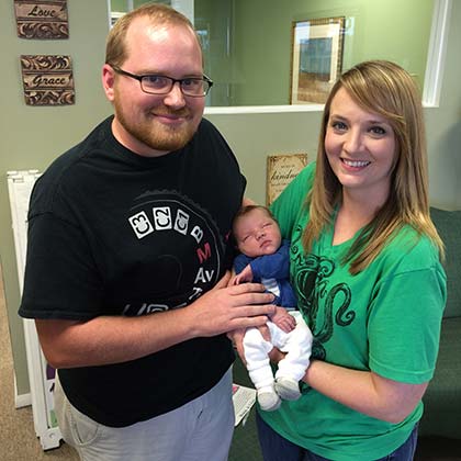 Young couple holding their newly adopted infant