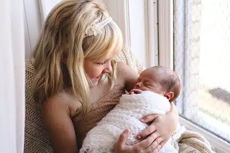 child holds new sibling and smiles