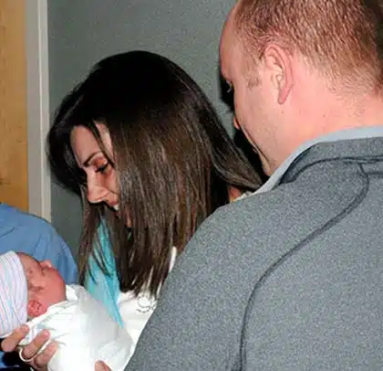 Adoptive parents look with joy at their new baby