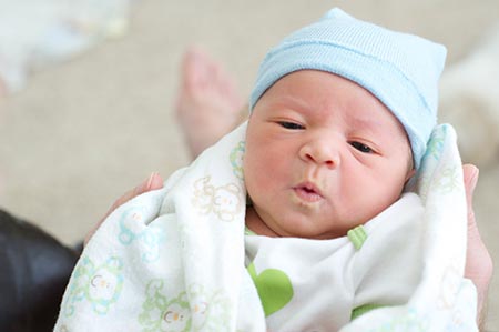 newborn baby opens eyes to look at camera