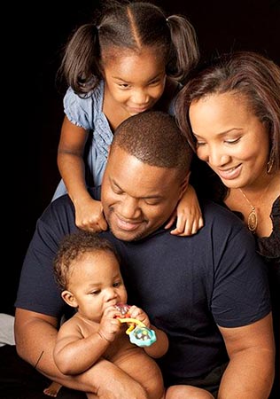 this African American family admires their new baby, their second adoption success