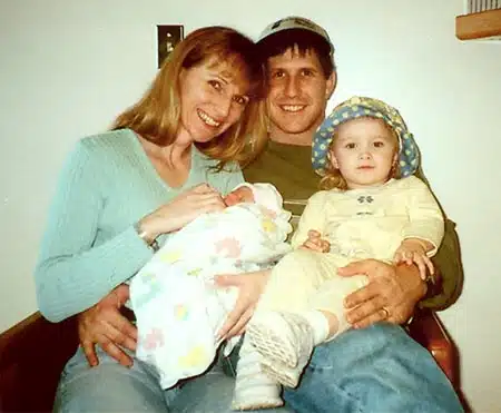 Happy married couple posing with child and their newly adopted infant after waiting for adoption