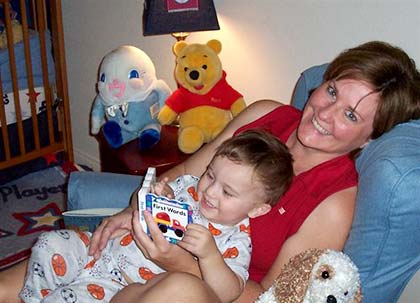 adoptive mom reads a book to her son in the nursery