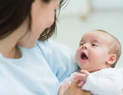 adoptive mother holds newborn in her arms at hospital, part of podcast on what open adoption is like