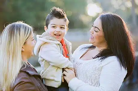 adoptive mother looks on as birth mother visits her son