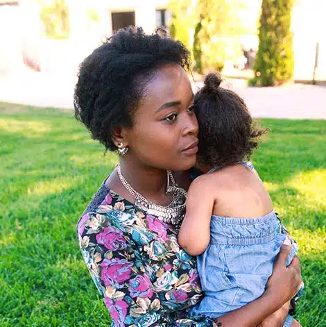 Pregnant woman holds daughter, thinking, 'I can't afford to raise another child!