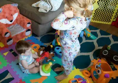 Adopted baby and biological child playing together, prepare your home for their safety