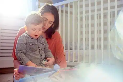 Adoptive mother reading a board book to her toddler son