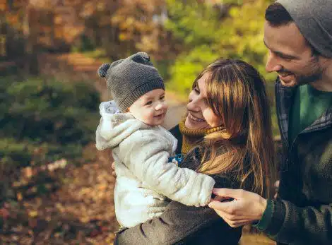 Woman and man gaze lovingly at infant son they adopted through a Christian adoption