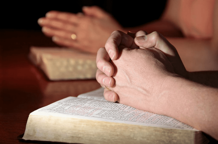 Married couple praying about Christian adoption