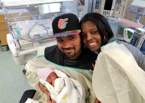 Happy adoptive couple holding their baby for the first time at the hospital