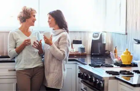 Woman and her mother chatting in the kitchen