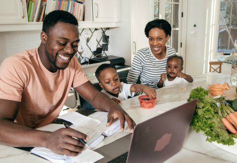 Adoptive father uses adoption tax credit happily while his wife and children look on