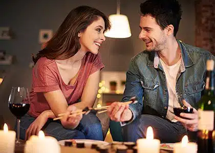 Young couple enjoying sushi and wine together