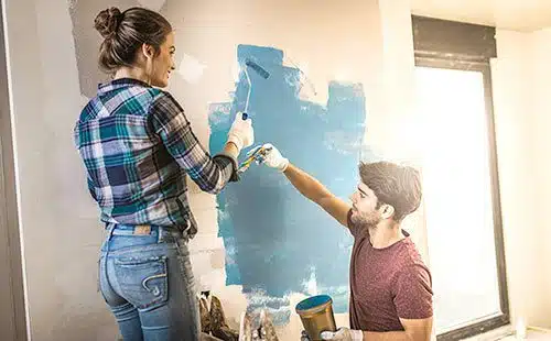 Adoptive couple happily paints their future baby's nursery
