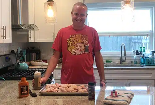 Patrick gets ready to apply rub to the chicken wings