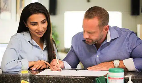 Hopeful adoptive parents filling out a home study application in their kitchen
