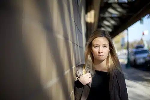 Young woman walking on a sidewalk in a downtown area