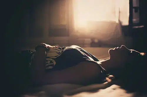 Woman lying on her bed, experiencing grief