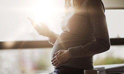 Pregnant woman with smartphone illustrates Birth Parents’ Right to Privacy in Adoption Planning