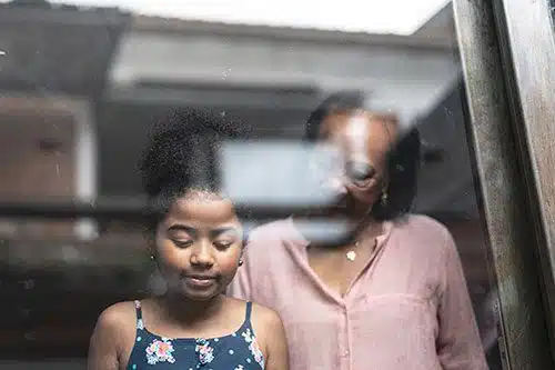 Grandma and granddaughter look out the window