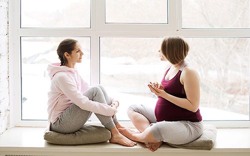 Pregnant woman talks about adoption with a friend