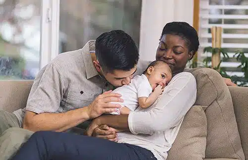 Loving adoptive couple with their newly-adopted infant