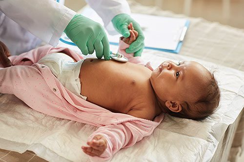 Pediatrician examines baby, measuring heart rate
