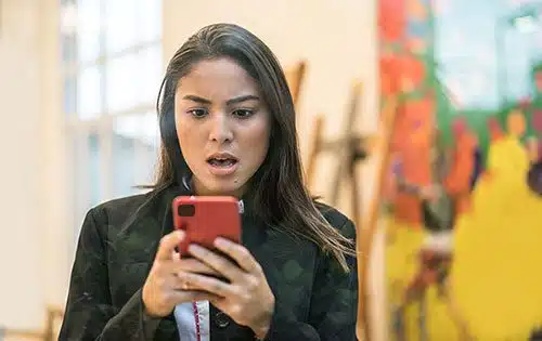 Woman looks at her cell phone, offended over one of the worst terms to use about adoption