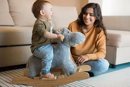 Baby on rocking horse with adoptive mom who learned how to adopt a baby with Lifetime Adoption