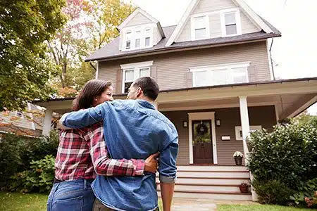 Adoptive couple in front of home