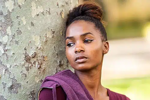 Young mixed-race woman deep in thought outside