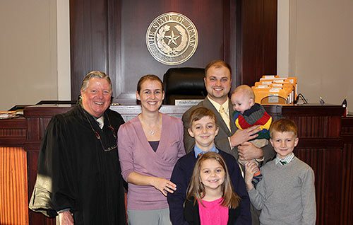 Adoptive family formed through Lifetime's help poses with the judge at their son's adoption finalization